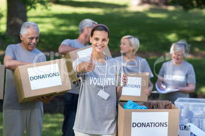 Happy volunteer brunette smiling with thumb up