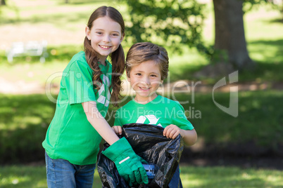 Happy siblings collecting rubbish