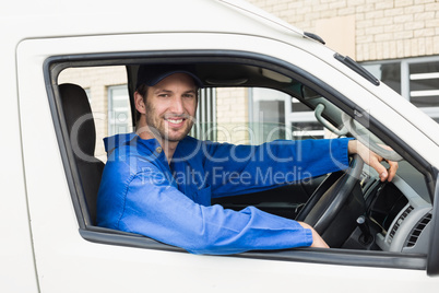 Delivery driver smiling at camera in his van