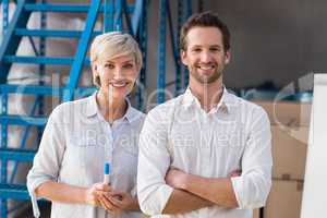 Smiling warehouse managers looking at camera