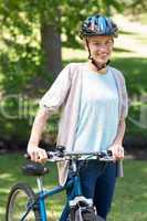 Happy blonde with her bike at the park