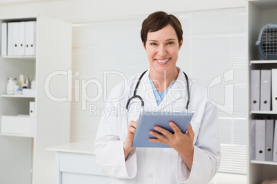 Smiling veterinarian and holding tablet