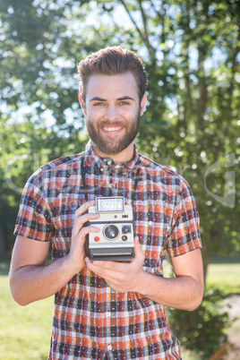 Handsome hipster holding vintage camera