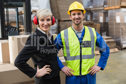 Warehouse worker and his manager with hands on hips