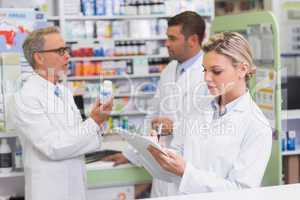 Focused pharmacist writing on clipboard