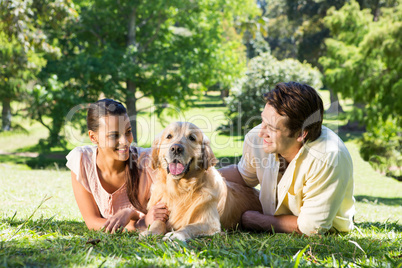 Happy couple with their dog in the park