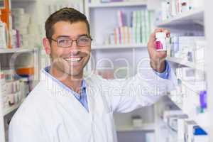 Handsome pharmacist holding medicine jar