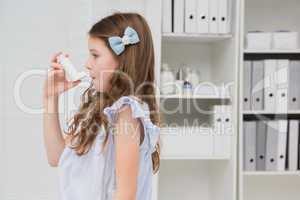 Little girl taking inhaler