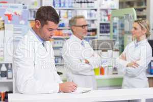 Pharmacist in lab coat writing a prescription