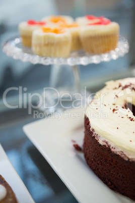 Display case of cupcakes and sweet cake