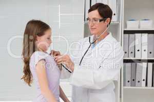 Doctor examining little girl