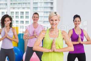 Women with hands joined exercising at gym