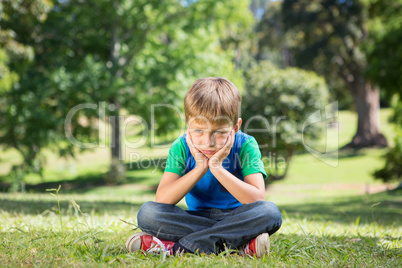 Little boy feeling sad in the park