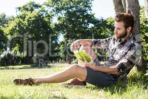 Handsome hipster reading book in park