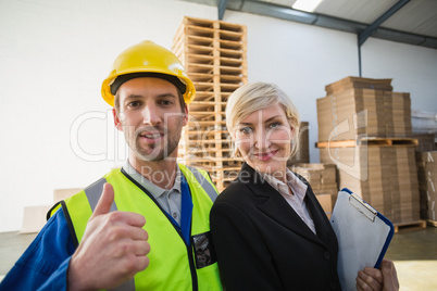 Portrait of smiling warehouse worker and his manager