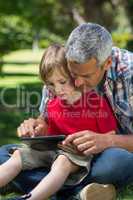 Happy father using tablet pc with his son