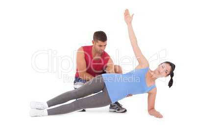 Trainer with woman in plank position