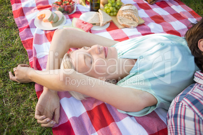 Happy couple sleeping together at the park