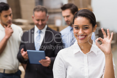 Smiling warehouse manager making okay gesture