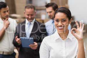 Smiling warehouse manager making okay gesture