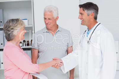 Senior couple smiling while visiting doctor