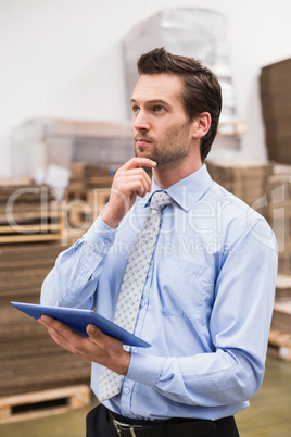 Manager using digital tablet in warehouse