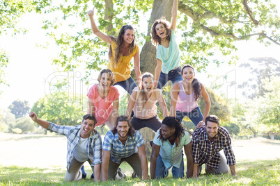 Happy friends in the park making human pyramid