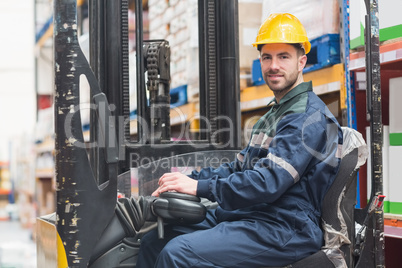 Driver operating forklift machine in warehouse