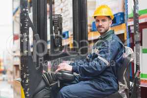 Driver operating forklift machine in warehouse