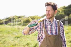 Happy farmer carrying his shovel