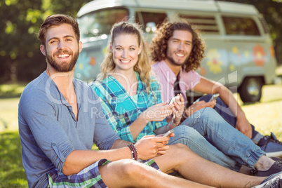 Hipsters sitting on the grass texting