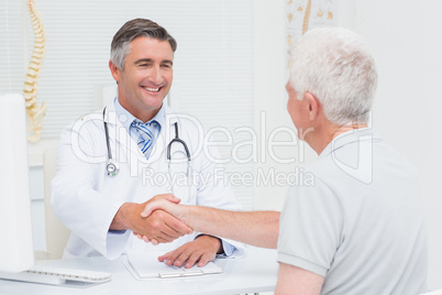 Doctor shaking hands with senior patient