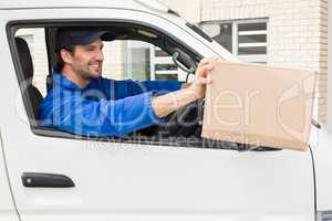 Delivery driver offering parcel from his van