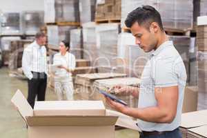 Manager using digital tablet in warehouse