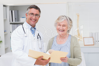 Happy male doctor and female patient with reports