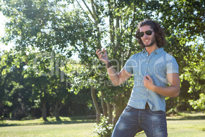 Young man playing air guitar in the park