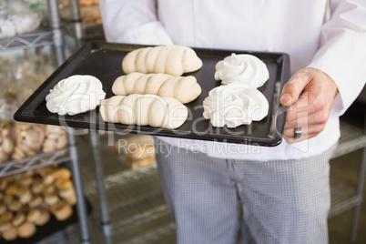 Mid section of baker holding meringue tray