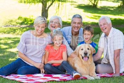 Happy family smiling at the camera with their dog