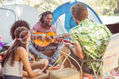 Hipster playing guitar for his friends