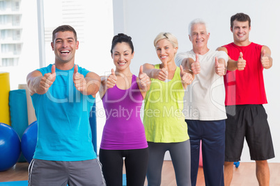 People gesturing thumbs up at gym