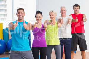 People gesturing thumbs up at gym