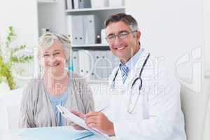 Happy doctor and female patient in clinic