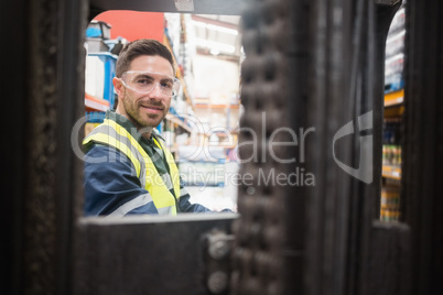 Smiling driver operating forklift machine