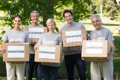Happy volunteer family holding donations boxes