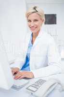 Confident female doctor using computer in clinic