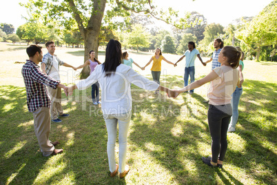 Happy friends in the park holding hands