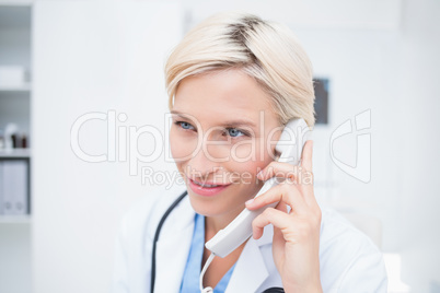 Doctor using telephone while looking away