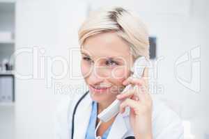 Doctor using telephone while looking away