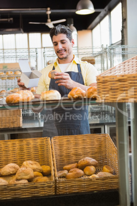 Smiling server holding bread and box