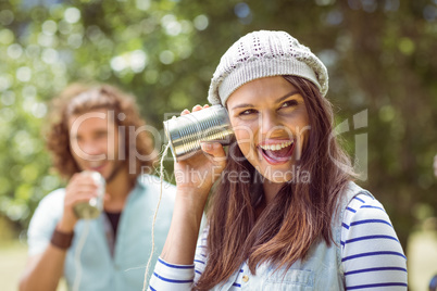Young couple shouting through tin cans